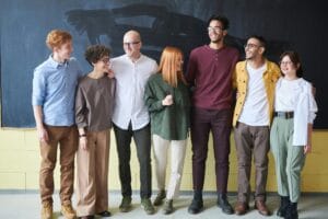 Quiz : Réussir sa prise de fonction de manager de proximité 1 A multicultural group of six adults standing happily together in a casual setting.