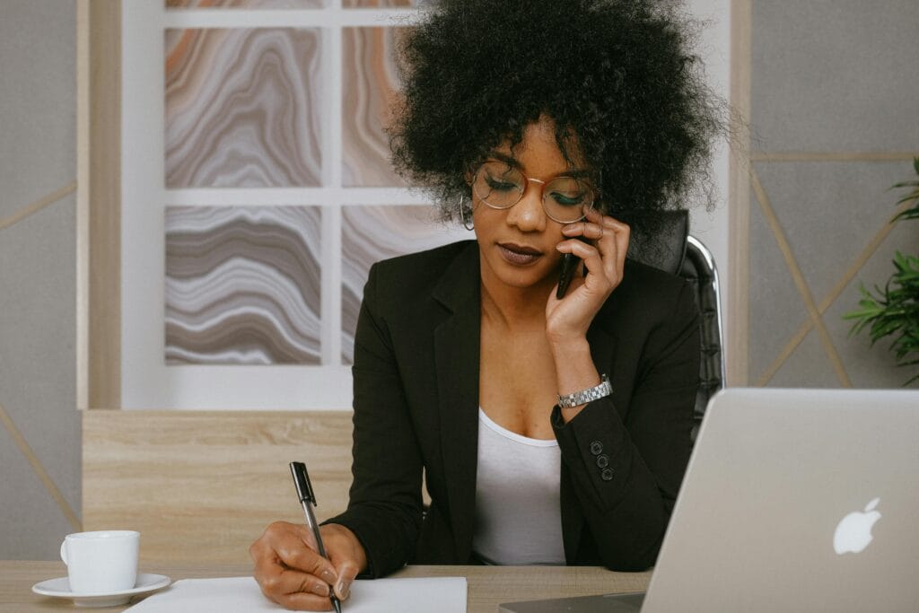 pexels-photo-3727469-3727469 Businesswoman making a phone call while working at the desk, focused and professional.
